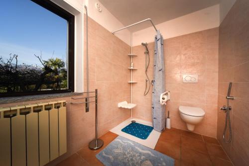 a bathroom with a shower and a toilet and a window at Il Guscio in Baveno