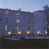 a large building with lights in front of it at Château de Fourcès in Fourcès