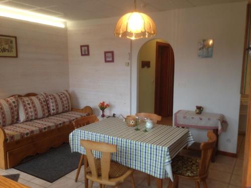 un salon avec une table et un canapé dans l'établissement Gites Les Pins et Les Bruyères, à Wangenbourg