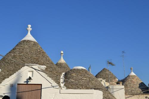 a group of roofs with a blue sky in the background at Trulli Aia Piccola in Alberobello