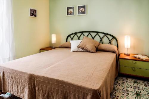 マリーナ・ディ・ラグーザにあるsiciliacasevacanze - Casa Maiolicaのベッドルーム1室(ベッド1台、ナイトスタンド2台、ランプ2つ付)