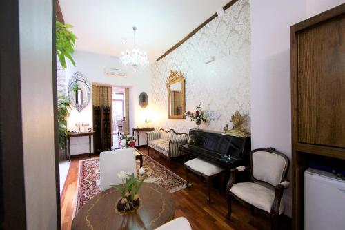 a living room with a piano and a table at Hotel Boutique Nueve Leyendas in Úbeda