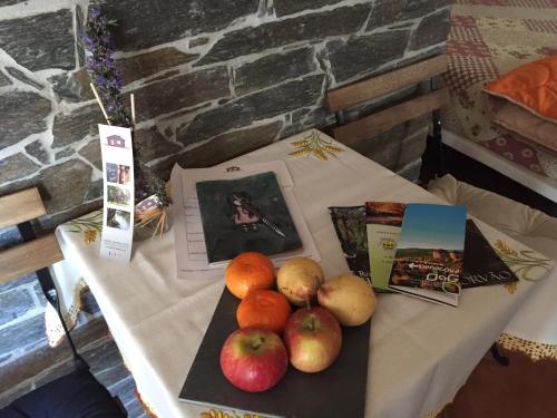 a table with fruit and pictures on it at Casinha de Pedra in Penacova