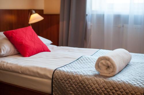 a hotel room with a towel on a bed at Hotel Komes in Skarżysko-Kamienna