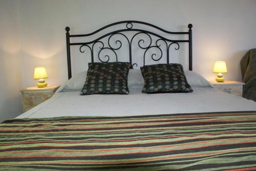 uma cama grande com duas almofadas e dois candeeiros em Cantinho do mar em Urzelina