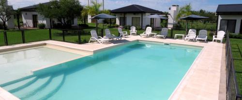 a large swimming pool with lounge chairs at Cabañas El Origen in Colón