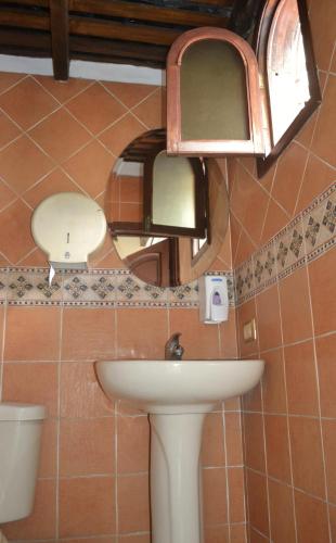 a bathroom with a sink and a mirror and a toilet at Hotel Villa Florencia Centro Histórico in San Salvador