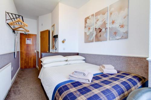 a bedroom with a bed with towels on it at New Brooklyn in Blackpool