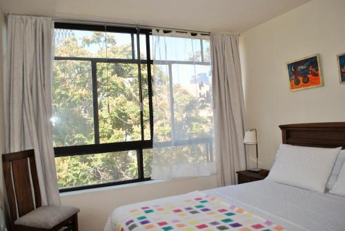 a bedroom with a bed and a large window at Santo Domingo frente Bellas Artes in Santiago