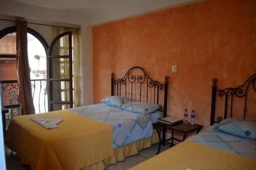 a bedroom with two beds and a window at Hotel Villa Florencia Centro Histórico in San Salvador