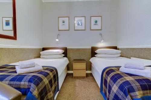 a room with two beds with blue and white sheets at New Brooklyn in Blackpool