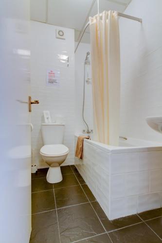 a bathroom with a toilet and a tub and a sink at New Brooklyn in Blackpool