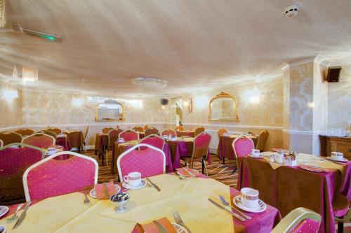 a dining room with pink tables and chairs at New Brooklyn in Blackpool