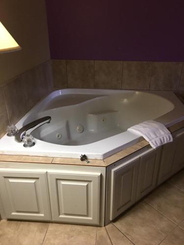 La salle de bains est pourvue d'une baignoire avec un robinet. dans l'établissement Econo Lodge Inn & Suites, à Greenbrier