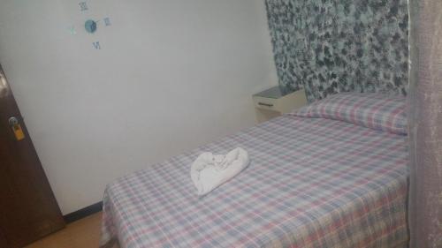 a bed with a heart shaped pillow on it at Hostal Lima in Valladolid