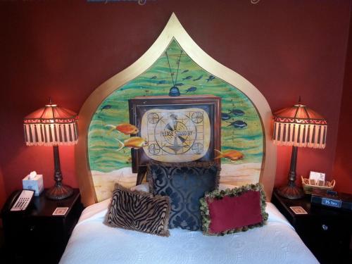 a clock sitting on top of a bed with two lamps at McMenamins Crystal Hotel in Portland