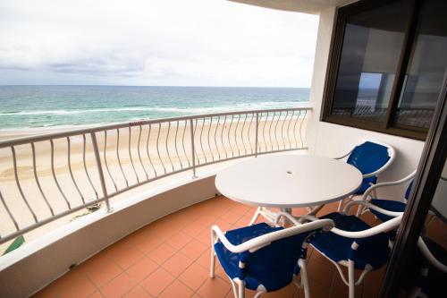 a balcony with a table and chairs and the ocean at Albatross North Apartments in Gold Coast
