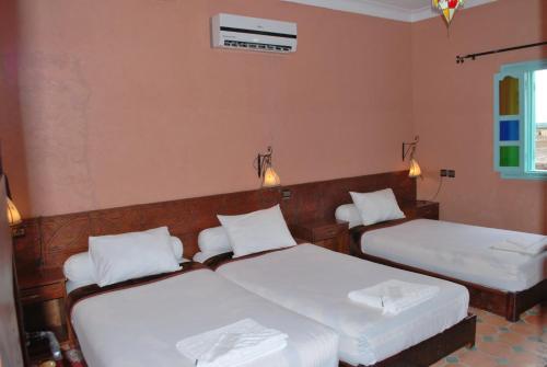 a bedroom with two beds with white pillows at Gite Souss in Oulad Teima