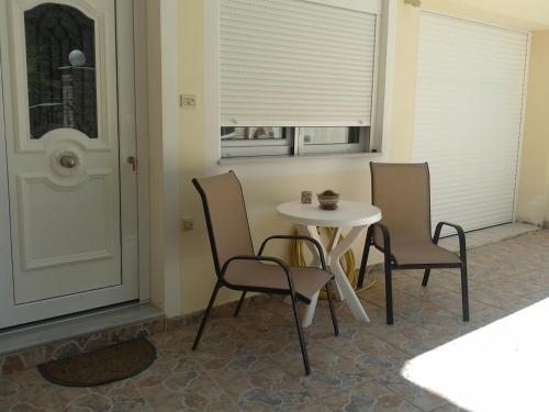 einen Tisch und Stühle in einem Zimmer mit Fenster in der Unterkunft Patra - Cute studio near center in Patras