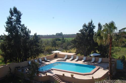 an outdoor swimming pool with chairs and a swimming poolvisor at Gite Souss in Oulad Teima