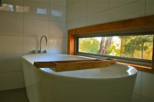 a bath tub in a bathroom with a window at Butterworth Accommodation in Castlemaine