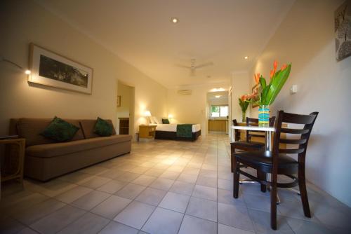 una sala de estar con un sofá y una mesa en Lazy Lizard Motor Inn, en Port Douglas