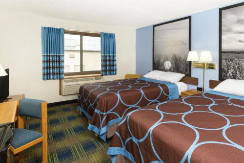 a hotel room with two beds and a desk at Super 8 by Wyndham Columbus in Columbus
