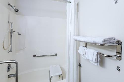 a bathroom with a shower and a towel rack at Super 8 by Wyndham Columbus in Columbus