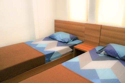 two beds in a small room with at Intech Hostel in Bandung