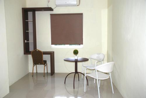 a table and chairs in a room with a window at Avon's Residence in Manado