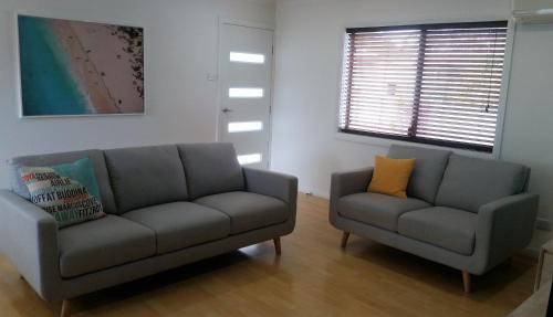 a living room with a couch and a chair at Karuah Riverside Motel in Karuah
