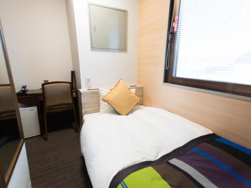 a hotel room with a bed and a window at Hotel AreaOne Nobeoka in Nobeoka