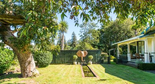 a yard with a chair and a fence at Gumnut House. in Whanganui