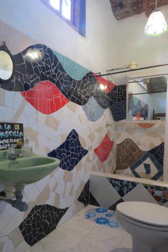 uma casa de banho com um lavatório e uma parede em mosaico em Tarragona Hostal em Santa Rosa de Cabal