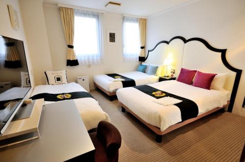 a hotel room with two beds and a table at Grand Park Hotel Panex Tokyo in Tokyo