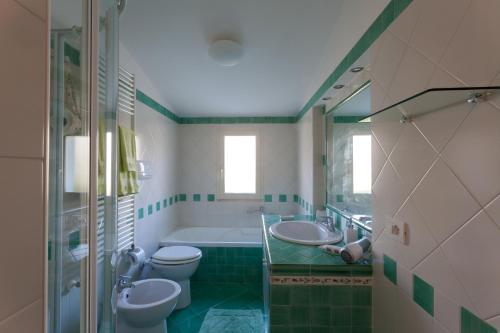 ラヴェッロにあるGarden Houseの緑と白のバスルーム(トイレ2つ、バスタブ付)
