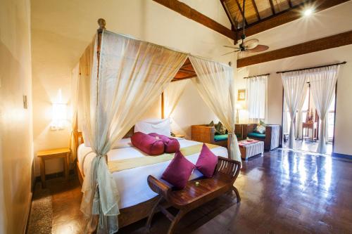 - une chambre avec un lit doté d'oreillers violets dans l'établissement Junjungan Ubud Hotel and Spa, à Ubud