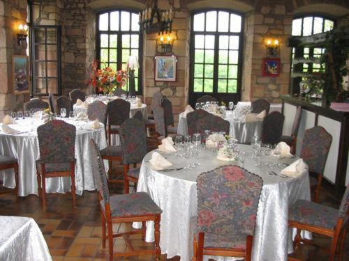 ein Esszimmer mit Tischen und Stühlen mit weißem Tischtuch in der Unterkunft Chateau De Latour in Latour