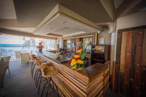 a bar in a restaurant with chairs and flowers at Voile Bleue Boutique Hotel in Trou aux Biches