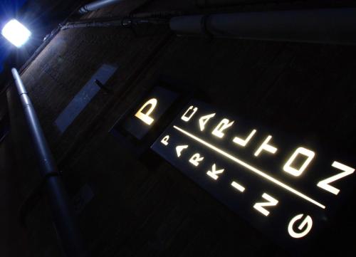 a sign that is lit up in the dark at Hotel Carlton in Ferrara