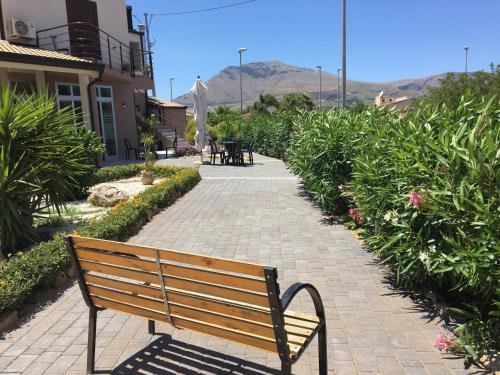 a park bench sitting on a brick walkway at Addisa Locazione Breve in Castellammare del Golfo