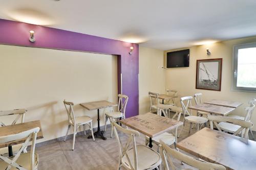 un restaurant avec des tables et des chaises en bois et un tableau blanc dans l'établissement Hotel Le Coudon, à La Farlède