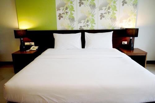 a large white bed in a room with two lamps at PS Hill Resort Phuket Patong - SHA Plus in Patong Beach
