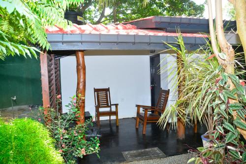 a patio with two chairs and a shed at Livinginn Polonnaruwa in Polonnaruwa