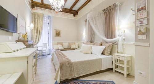 a white bedroom with a bed and a desk at Vecchia Verona Rooms & Apartments in Verona