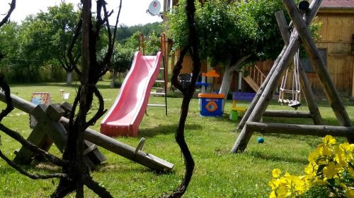 a playground with a pink slide in a yard at Villa Jun Guest House in Belogradchik