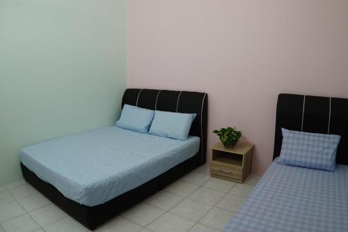 - une chambre avec un lit et une table de nuit dans l'établissement Taiping Cozy Homestay, à Taiping