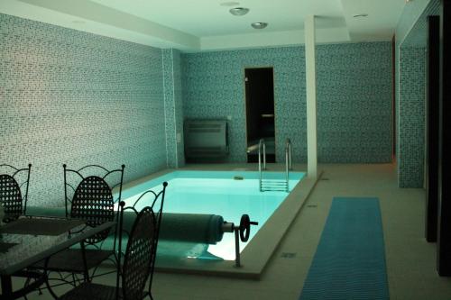una piscina en una habitación con sillas y mesa en Gilija, en Šilutė