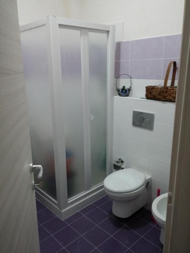 uma casa de banho com um WC e uma cabina de duche em vidro. em Casa vacanze a Pachino em Pachino