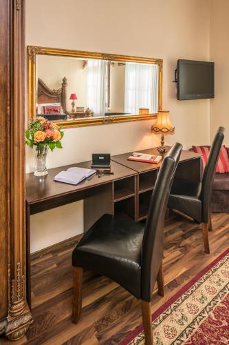 a hotel room with a desk and a mirror at Hotel Maria Helena in Szczawno-Zdrój